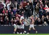 Heart of Midlothian's Lawrence Shankland, obscured, is mobbed by his teammates after scoring his side's third goal during the Scottish Premiership soccer match between Heart of Midlothian and Celtic, in Edinburgh, Sunday, Oct. 26, 2025. (Steve Welsh/PA via AP)