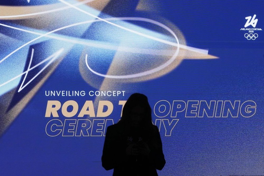 A woman is silhouetted during the Organising Committee for the Olympic and Paralympic Winter Games 2026 press conference unveiling the concept of the opening ceremony of the Milano-Cortina Winter Olympics, at Milan's San Siro stadium, Italy, Thursday, Oct. 16, 2025. (AP Photo/Antonio Calanni)