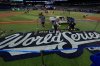 Blue Jays grounds crew members Coleton Miller, centre, and Jake Matthew, right, work on the World Series logo during a baseball media day on Oct. 23, 2025, in Toronto. The Toronto Blue Jays face the Los Angeles Dodgers in Game 1 on Friday. (AP Photo/David J. Phillip)
