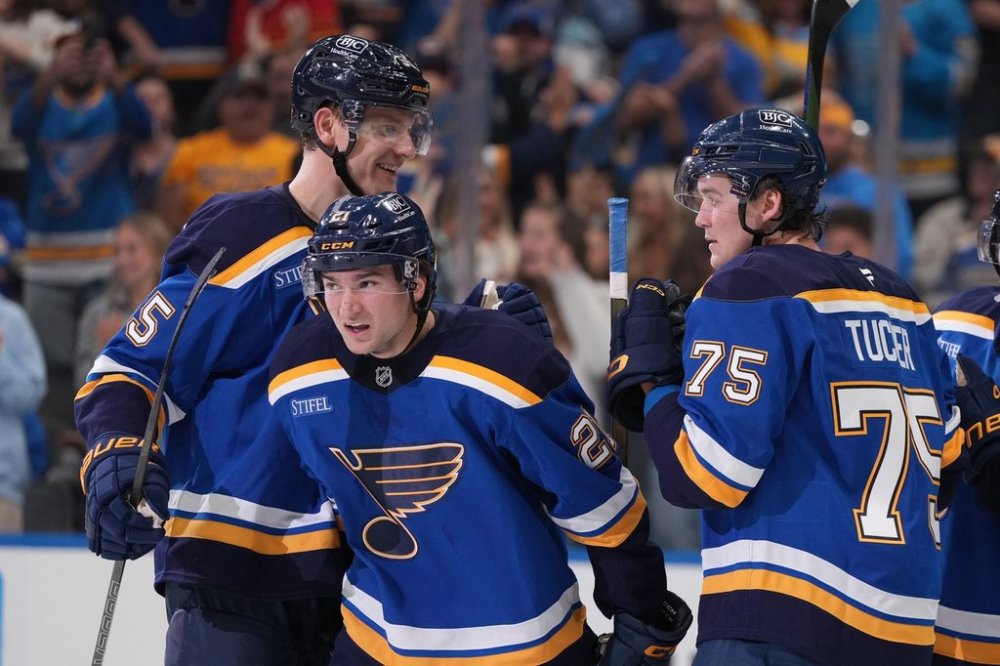 St. Louis Blues' Jimmy Snuggerud (21) is congratulated by Colton Parayko, left, and Tyler Tucker (75) after scoring during the second period of an NHL hockey game against the Dallas Stars Saturday, Oct. 18, 2025, in St. Louis. (AP Photo/Jeff Roberson)