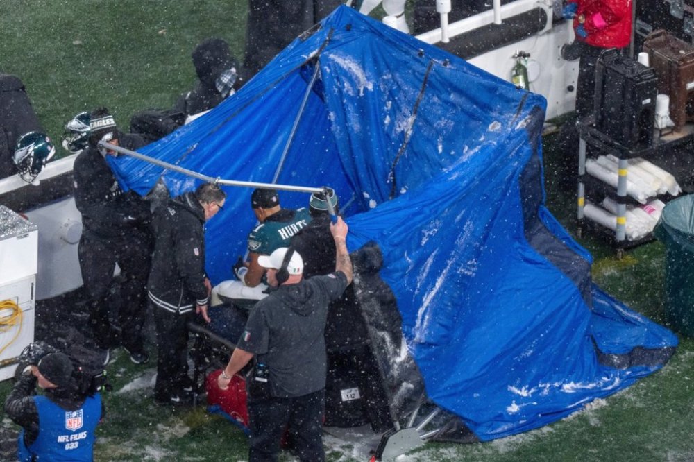 FILE - Philadelphia Eagles quarterback Jalen Hurts (1) sits as they pull the blue tent over him during the NFL divisional playoff football game against the Los Angeles Rams, Jan. 19, 2025, in Philadelphia. (AP Photo/Chris Szagola, File)