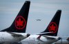 Air Canada aircraft sit parked at Vancouver International Airport as a United Airlines flight from Chicago prepares to land, in Richmond, B.C., on Monday, Aug. 18, 2025. THE CANADIAN PRESS/Darryl Dyck