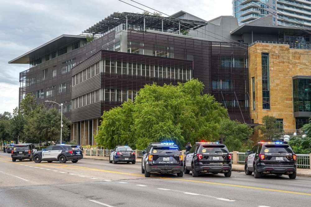 Police vehicles block the street after reports of a shooting at the Austin Public Library on César Chávez Street in downtown Austin, Texas on Saturday, Oct. 25, 2025. (Aaron E. Martinez/Austin American-Statesman via AP)