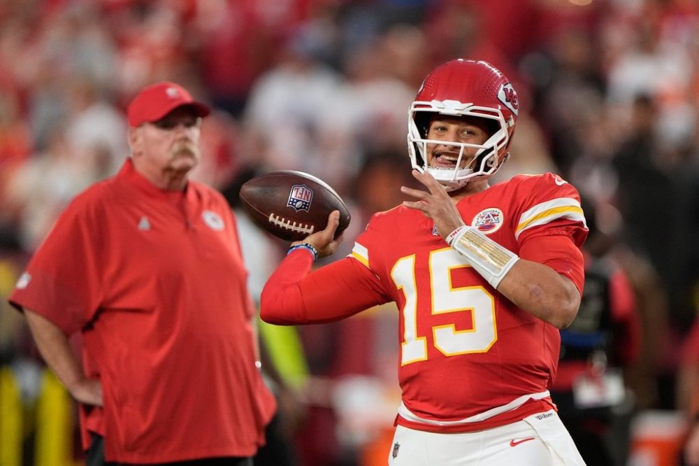 Kansas City Chiefs quarterback Patrick Mahomes (15) warms up as head coach Andy Reid, left, watches before an NFL football game against the Detroit Lions Sunday, Oct. 12, 2025, in Kansas City, Mo. (AP Photo/Charlie Riedel)