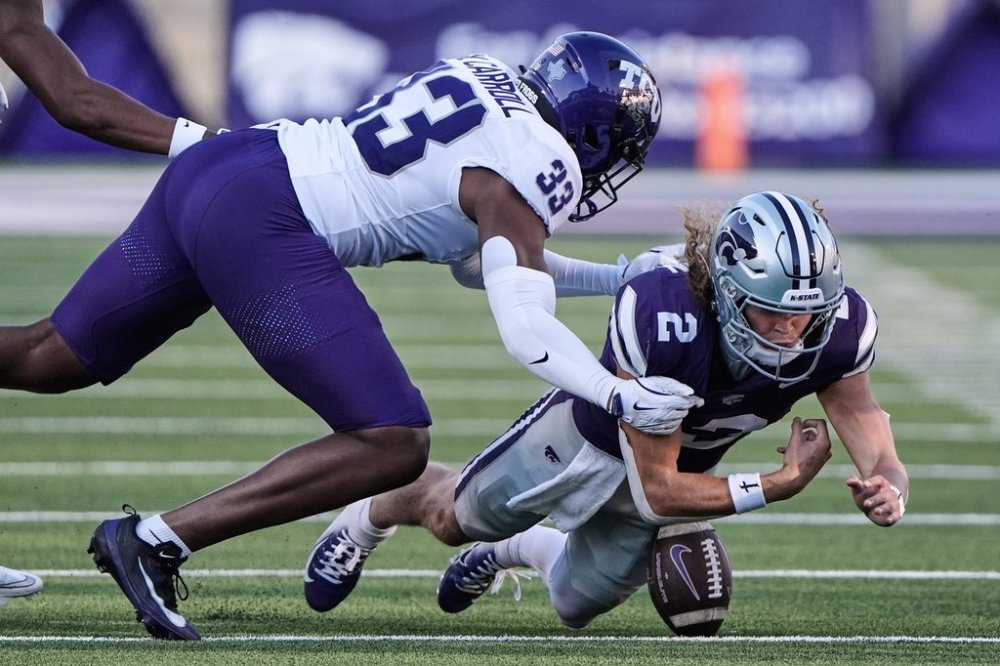 Kansas State quarterback Avery Johnson (2) recovers his own fumble for a first down as he is tackled by TCU linebacker Max Carroll (33) during the second half of an NCAA college football game Saturday, Oct. 11, 2025, in Manhattan, Kan. (AP Photo/Charlie Riedel)