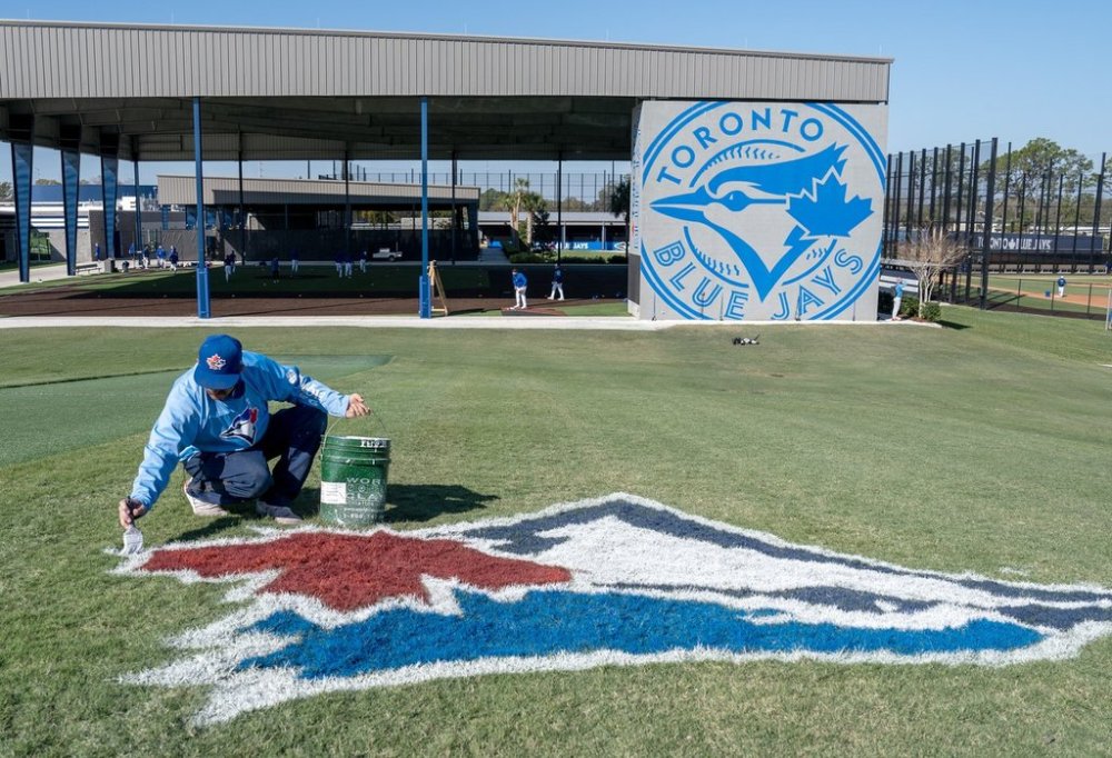 A painter touches up the Toronto Blue Jays logo on the training hill at the Spring Training facility in Dunedin, Fla. on February 21, 2024. THE CANADIAN PRESS/Frank Gunn