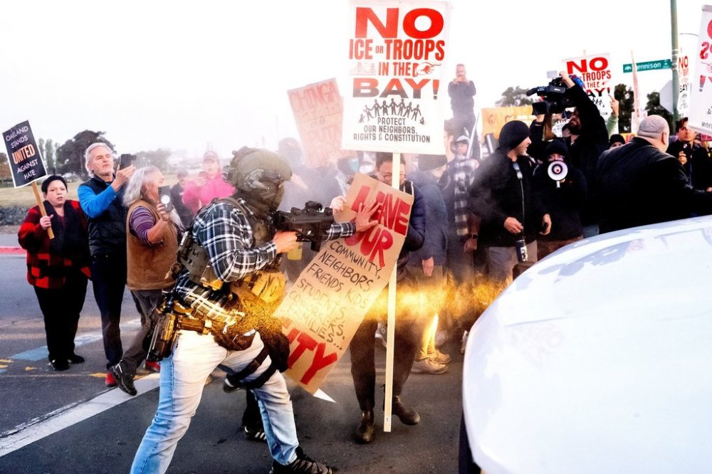 A person pushes a protester blocking a caravan of U.S. Customs and Border Protection personnel trying to enter Coast Guard Base Alameda on Thursday, Oct. 23, 2025, in Oakland, Calif. (AP Photo/Noah Berger)