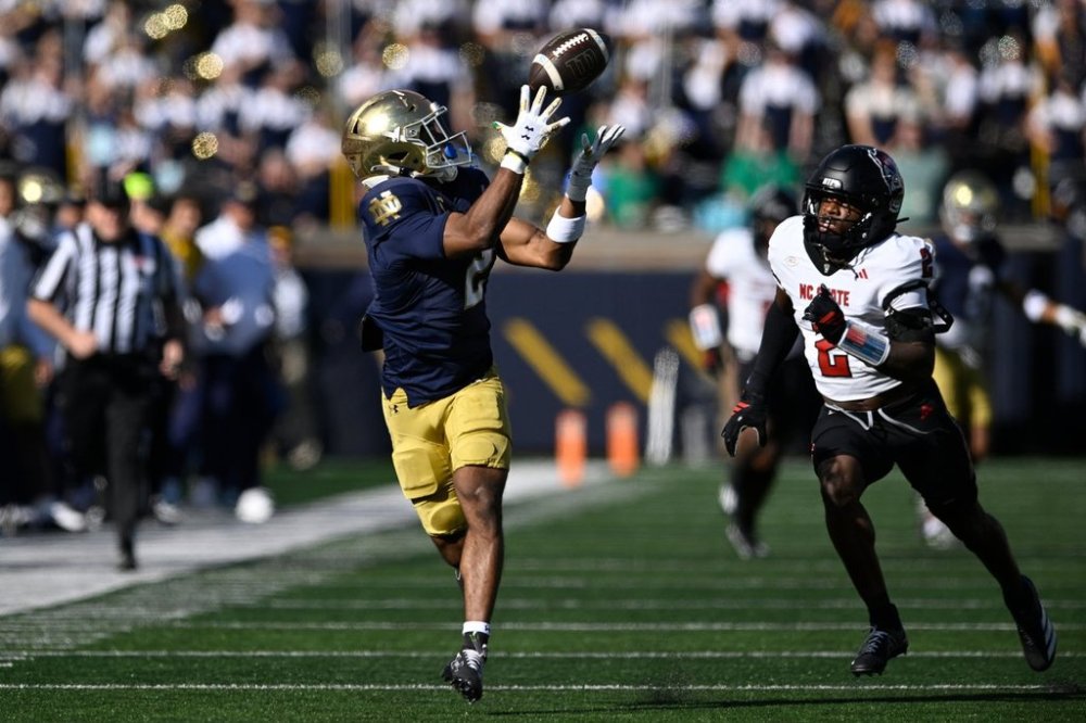 Notre Dame wide receiver Will Pauling, left, catches a pass against North Carolina State's Ronnie Royal lll, right, during the first quarter of an NCAA college football game Saturday, Oct. 11, 2025, in South Bend, Ind. (AP Photo/Paul Beaty)