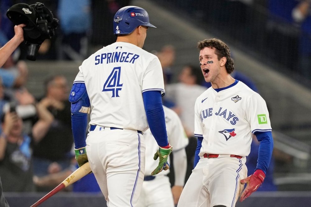 Toronto Blue Jays' Ernie Clement celebrates with George Springer after scoring on a double by Andrés Giménez during the sixth inning in Game 7 of baseball's World Series against the Los Angeles Dodgers, Saturday, Nov. 1, 2025, in Toronto. (AP Photo/Brynn Anderson)