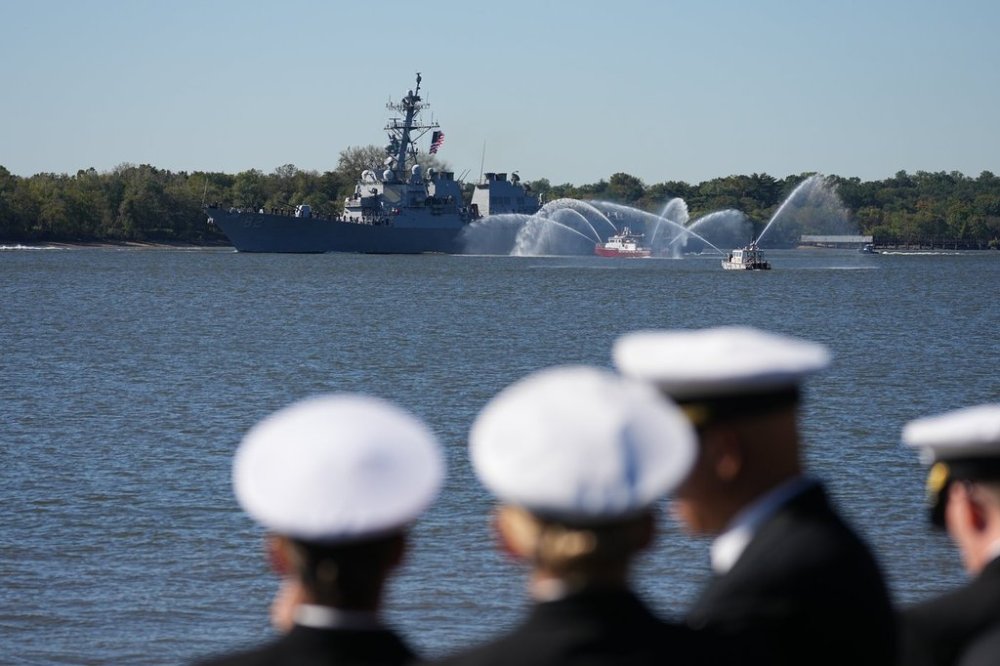 Spectators look on as U.S. Navy ships pass the viewing stand during the 250th anniversary of the founding of the U.S. Navy and Marine Corps, along the Delaware River, Thursday, Oct. 9, 2025, in Philadelphia. (AP Photo/Matt Rourke)