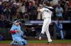 Seattle Mariners' Eugenio Suárez celebrates his solo home run during the second inning in Game 5 of baseball's American League Championship Series as Toronto Blue Jays Alejandro Kirk, left, look on, Friday, Oct. 17, 2025, in Seattle. (AP Photo/Lindsey Wasson)