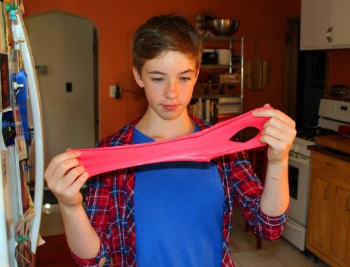 FILE - Astrid Rubens demonstrates the elasticity of homemade slime in her kitchen in St. Paul, Minn., June 21, 2017. (AP Photos/Jeff Baenen, File)