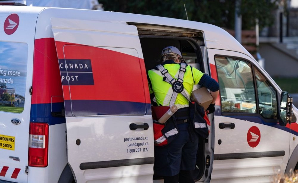 A Canada Post mail carrier delivers packages on their route in Montreal on Wednesday, Nov. 13, 2024. Planned reforms to mail delivery raise questions over the future of the century-and-a-half-old institution and what form it will need to take in an era where digitization and private competitors threaten its survival. THE CANADIAN PRESS/Christinne Muschi