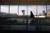 A traveler moves in view of a control tower at Philadelphia International Airport in Philadelphia, Wednesday, Nov. 5, 2025. (AP Photo/Matt Rourke)