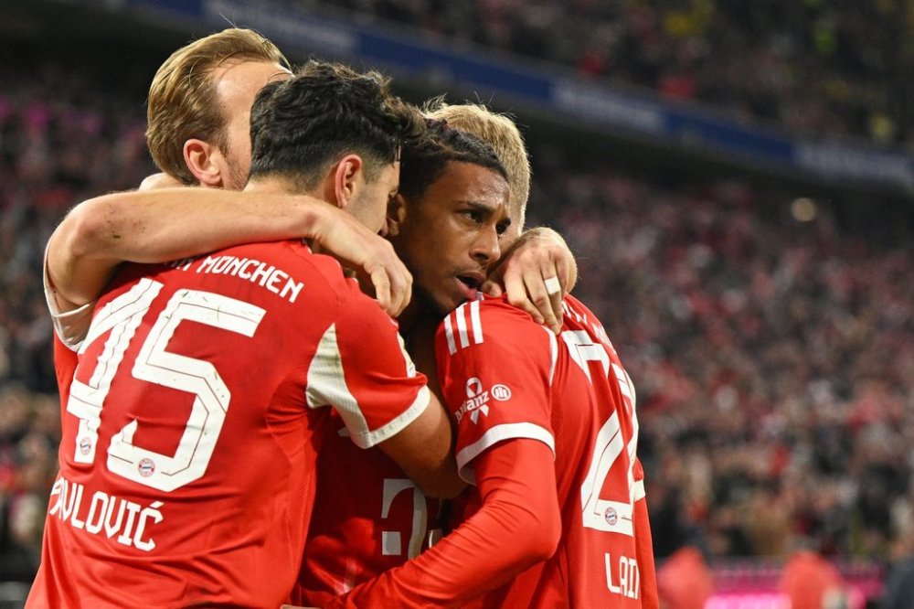 Bayern's Michael Olise, centre, celebrates with teammates after scoring his side's second goal during the Bundesliga soccer match between Bayern Munich and Borussia Dortmund in Munich, Germany, Saturday, Oct. 18, 2025. (AP Photo/Lennart Preiss)