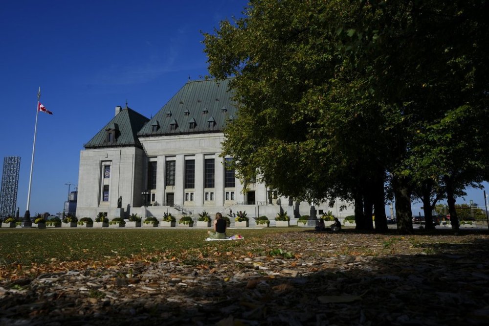 People take a break on the front lawn of the Supreme Court of Canada in Ottawa on Monday, Oct. 6, 2025. THE CANADIAN PRESS/Sean Kilpatrick