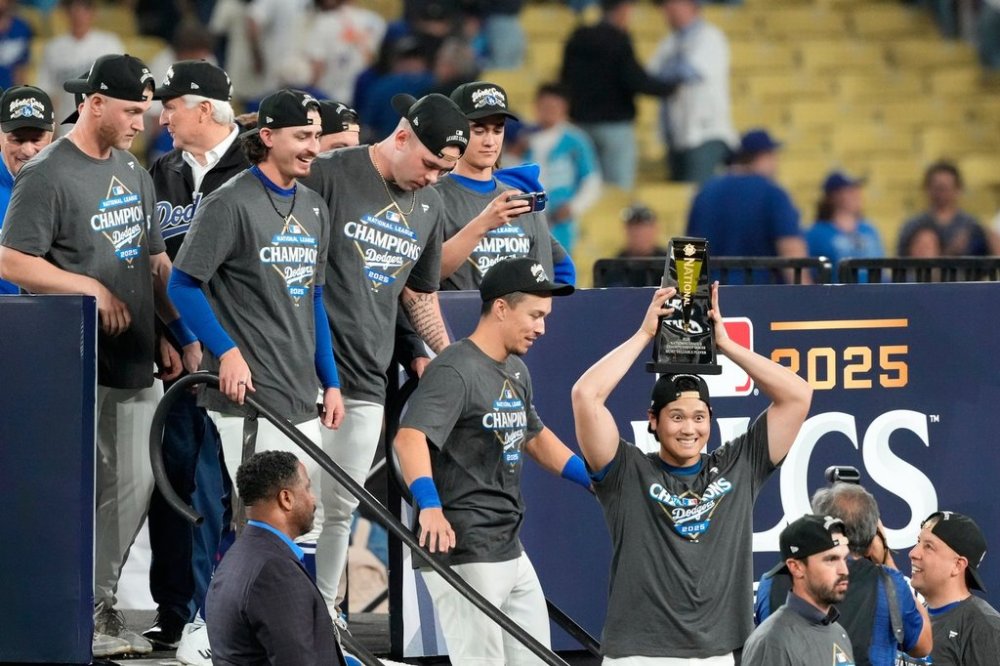 Los Angeles Dodgers' Shohei Ohtani celebrates the the trophy after their win against the Milwaukee Brewers in baseball's National League Championship Series, Friday, Oct. 17, 2025, in Los Angeles. (AP Photo/Mark J. Terrill)