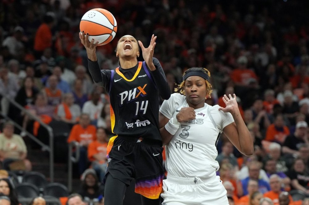Phoenix Mercury forward DeWanna Bonner (14) drives past Las Vegas Aces forward NaLyssa Smith during the second half of Game 3 of the WNBA basketball finals, Wednesday, Oct. 8, 2025, in Phoenix. (AP Photo/Rick Scuteri)