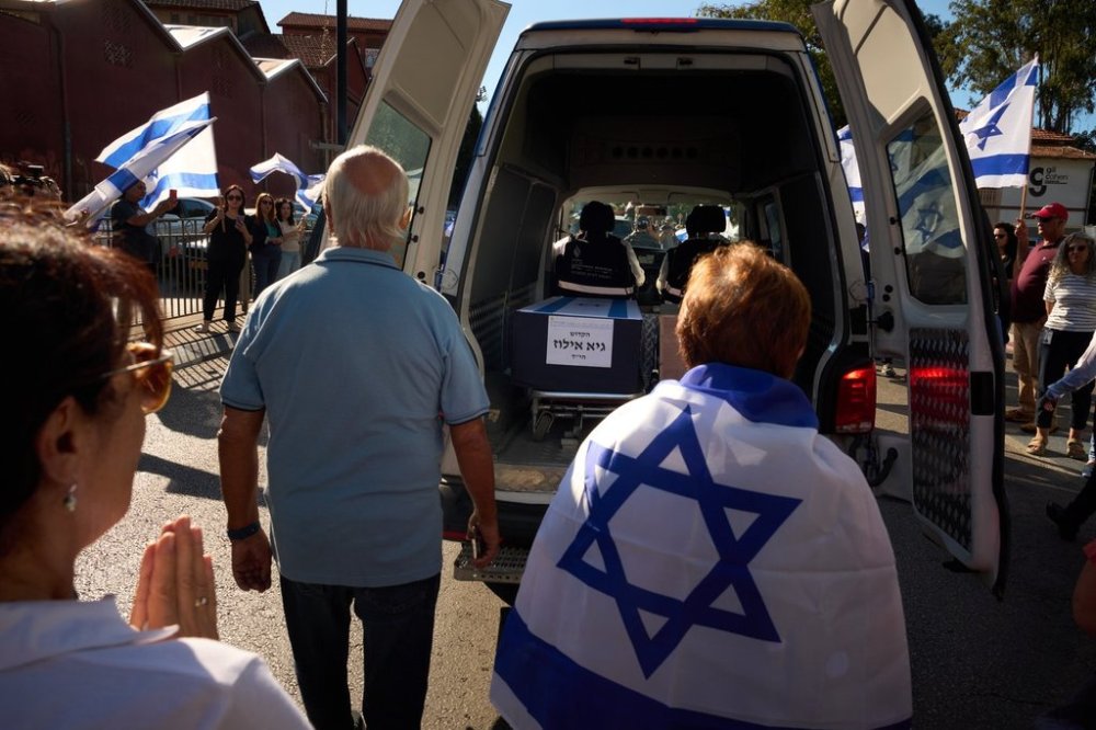 Mourners walk near the car carrying the coffin of slain hostage Guy Illouz during his funeral procession in Rishon Lezion, Israel, Wednesday, Oct. 15, 2025. Illouz remains were returned from Gaza to Israel as part of a ceasefire agreement between Israel and Hamas. (AP Photo/Emilio Morenatti)