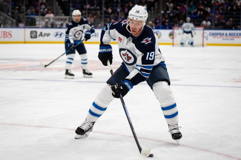 Winnipeg Jets center Jonathan Toews (19) controls the puck during the second period of an NHL hockey game against the New York Islanders, Monday, Oct. 13, 2025, in Elmont, N.Y. (AP Photo/Angelina Katsanis)