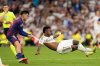 Barcelona's Pedri pulls Real Madrid's Vinicius Junior during a La Liga soccer match between Real Madrid and Barcelona in Madrid, Spain, Sunday, Oct. 26, 2025. (AP Photo/Bernat Armangue)
