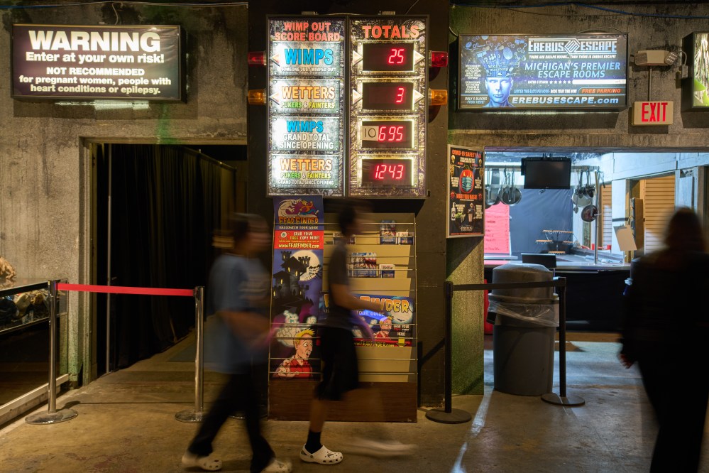 Visitors walk past an electronic