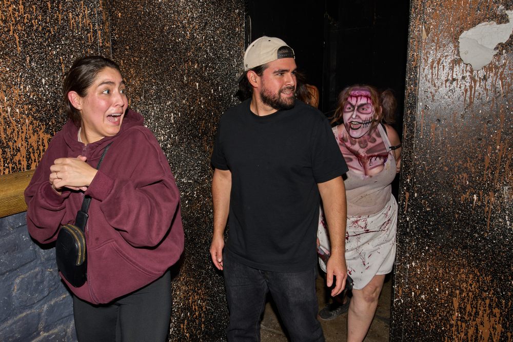Visitors react while attending the Erebus Haunted House, Oct. 4, 2025, in Pontiac, Mich. (AP Photo/Ryan Sun)