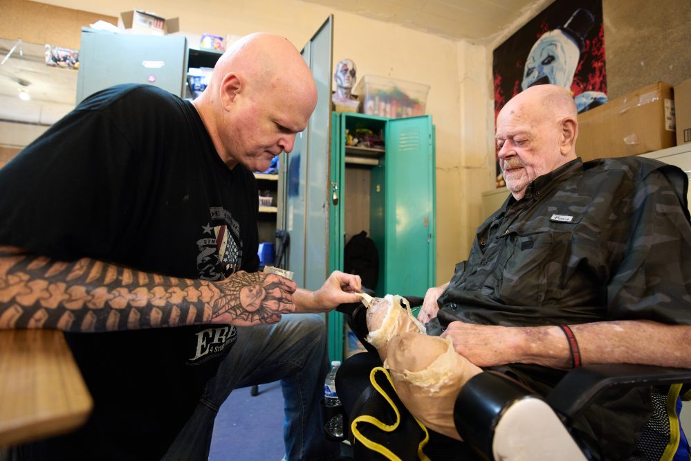 Leonard Noe, right, gets his make up done by his sone Tracy Noe, both of Westland, at the Erebus Haunted House, Oct. 2, 2025, in Pontiac, Mich. (AP Photo/Ryan Sun)