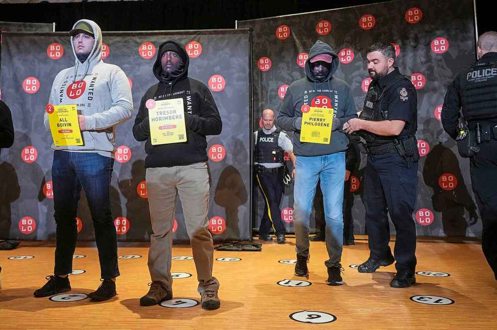 Police officers acting as models wearing masks bearing the faces of wanted fugitives stand during a Bolo Program news conference, in Vancouver, on Wednesday, Oct. 8, 2025. The B.C. RCMP along with 15 other Canadian police agencies and the Bolo Program announced the top 25 wanted Canadian fugitives. THE CANADIAN PRESS/Darryl Dyck