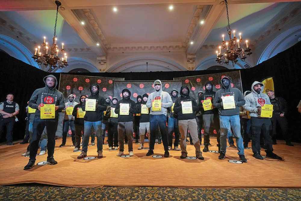 Police officers acting as models wearing masks bearing the faces of wanted fugitives stand during a Bolo Program news conference, in Vancouver, on Wednesday, Oct. 8, 2025. The B.C. RCMP along with 15 other Canadian police agencies and the Bolo Program announced the top 25 wanted Canadian fugitives. THE CANADIAN PRESS/Darryl Dyck