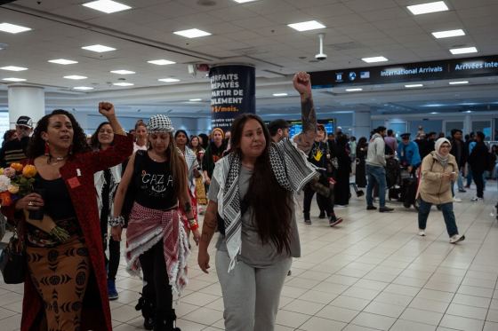 Mskwaasin Agnew, dressed in grey, raises her arm and joins with supporters after her return to Canada at Toronto Pearson International Airport on Oct. 11, 2025, following her detention by Israel(The Canadian Press/Handout/Joshua Best)