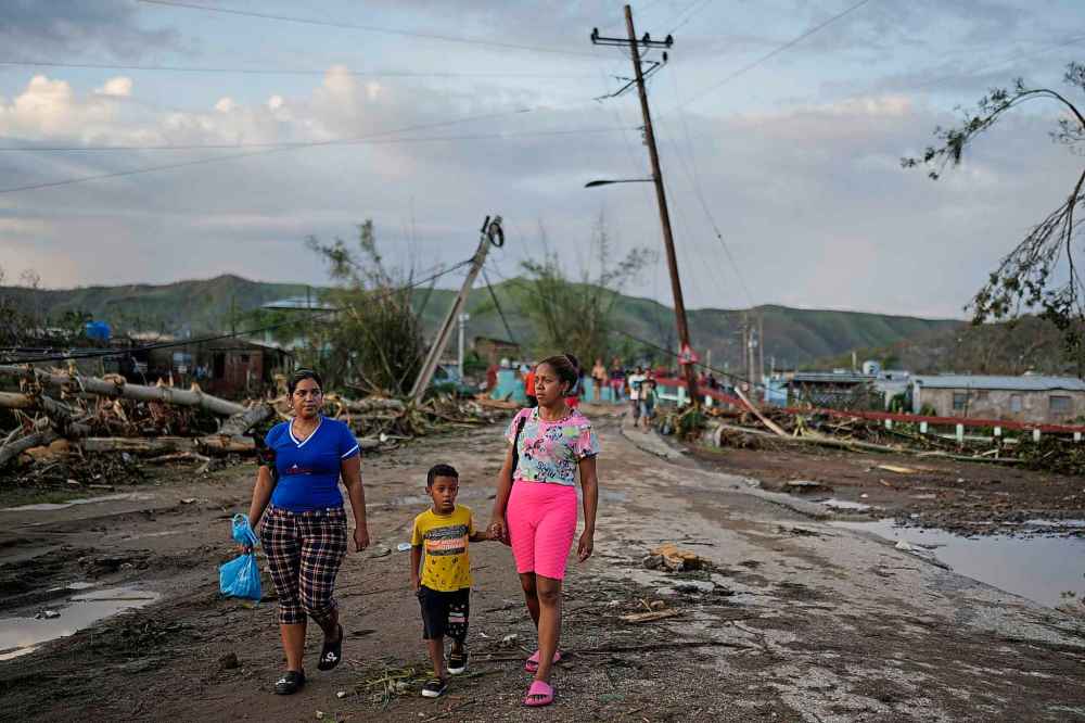 Residents walk in the aftermath of Hurricane Melissa in El Cobre, Cuba, Wednesday, Oct. 29, 2025. (AP Photo/Ramon Espinosa)