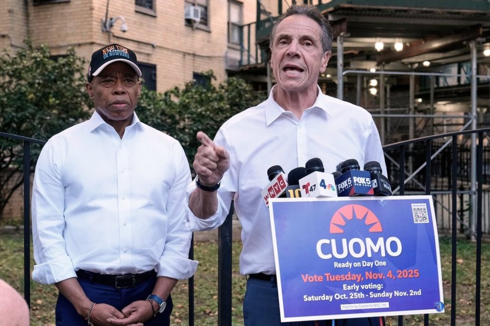 New York Mayor Eric Adams, left, and Democrat mayoral candidate Andrew Cuomo appear at a campaign event outside the George Washington Carver Houses, in New York, Thursday, Oct. 23, 2025. (AP Photo/Richard Drew)