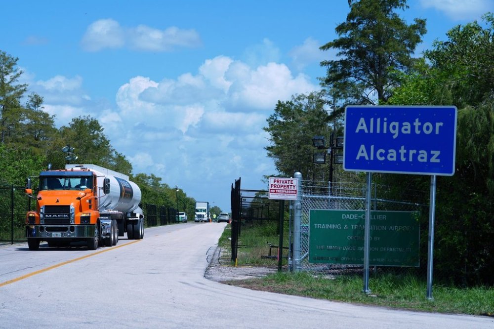 FILE - Trucks come and go from the