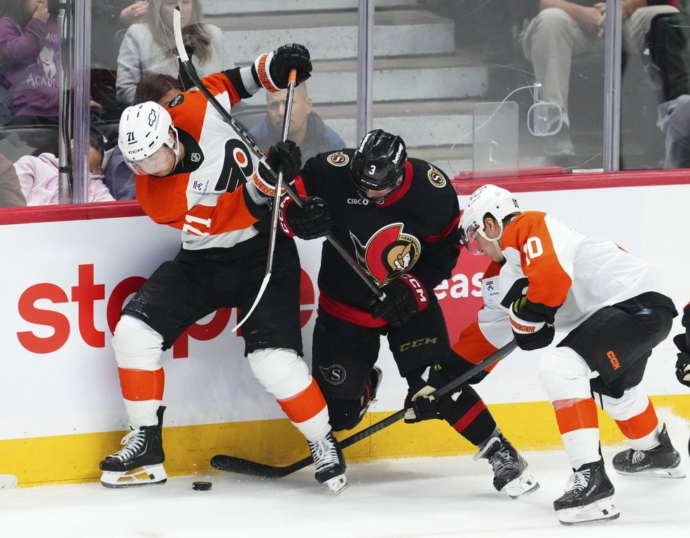 Philadelphia Flyers' Tyson Foerster (71) and teammate Bobby Brink (10) fight for the puck against Ottawa Senators' Nick Jensen (3) during third period NHL hockey action in Ottawa on Thursday, Oct. 23, 2025. THE CANADIAN PRESS/Sean Kilpatrick