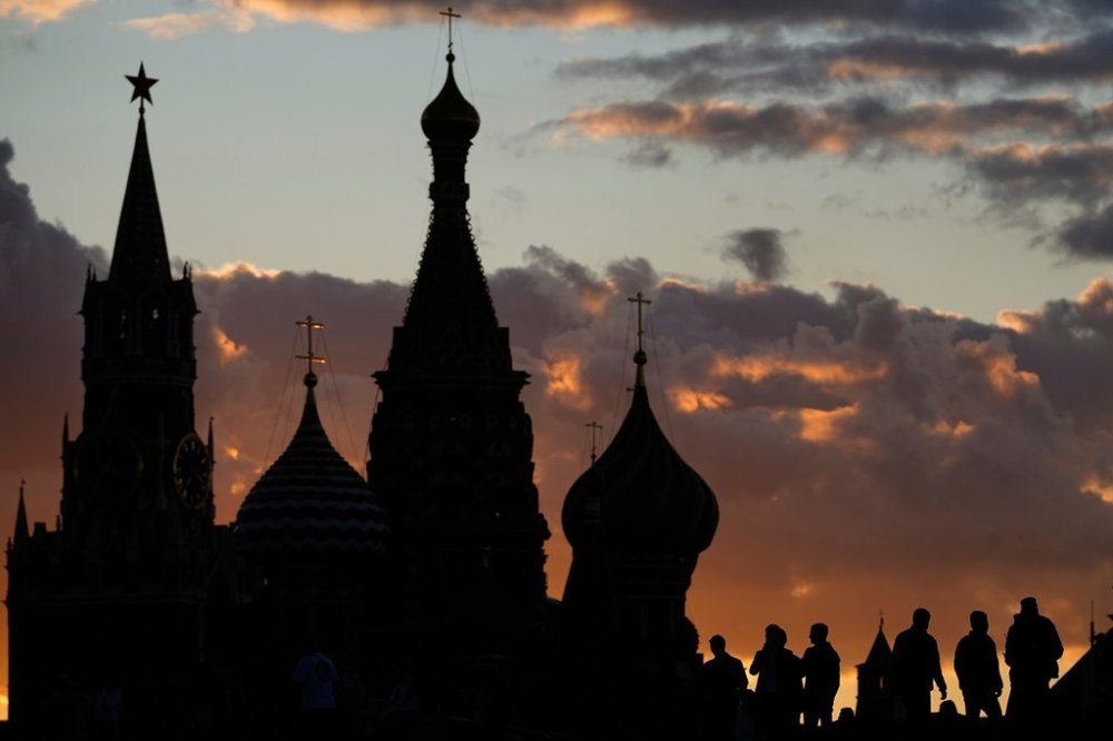 FILE - People walk at Zaryadye park in Moscow, Russia, on Aug. 28, 2025, with the Spasskaya tower of the Kremlin and St. Basil's Cathedral in the background. (AP Photo/Pavel Bednyakov, File)