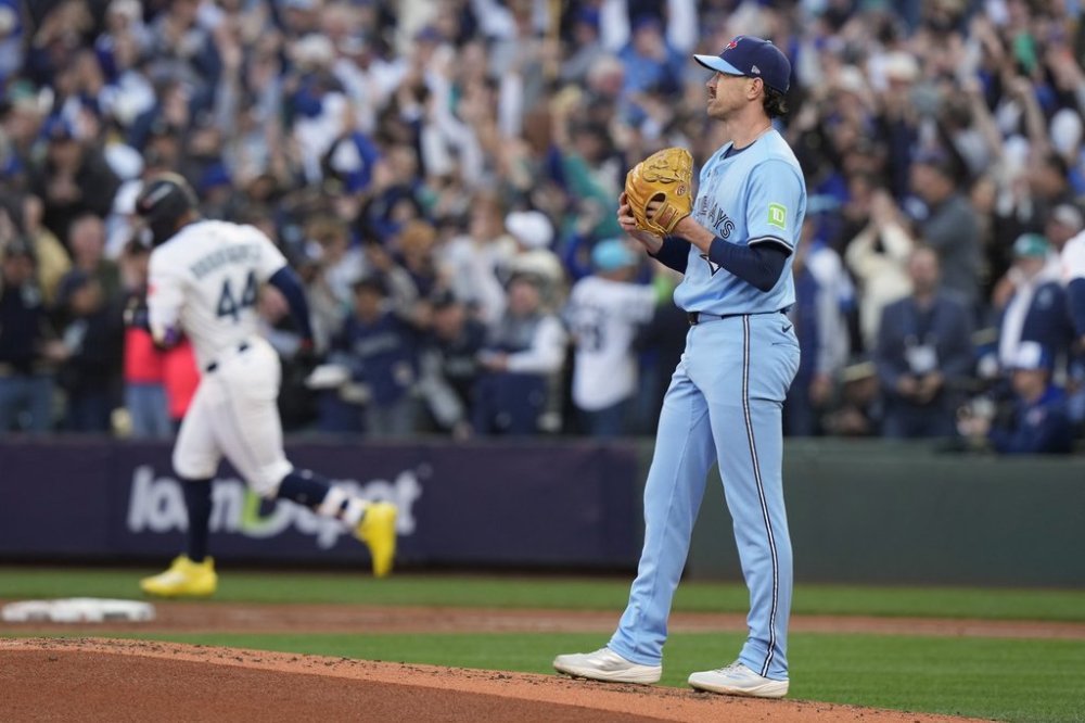 Toronto Blue Jays pitcher Shane Bieber (57) looks on as Seattle Mariners' Julio Rodríguez (44) rounds first base after hitting a two-run home run during first inning Game 3 American League Championship Series baseball action in Seattle on Wednesday, Oct. 15, 2025. THE CANADIAN PRESS/Frank Gunn