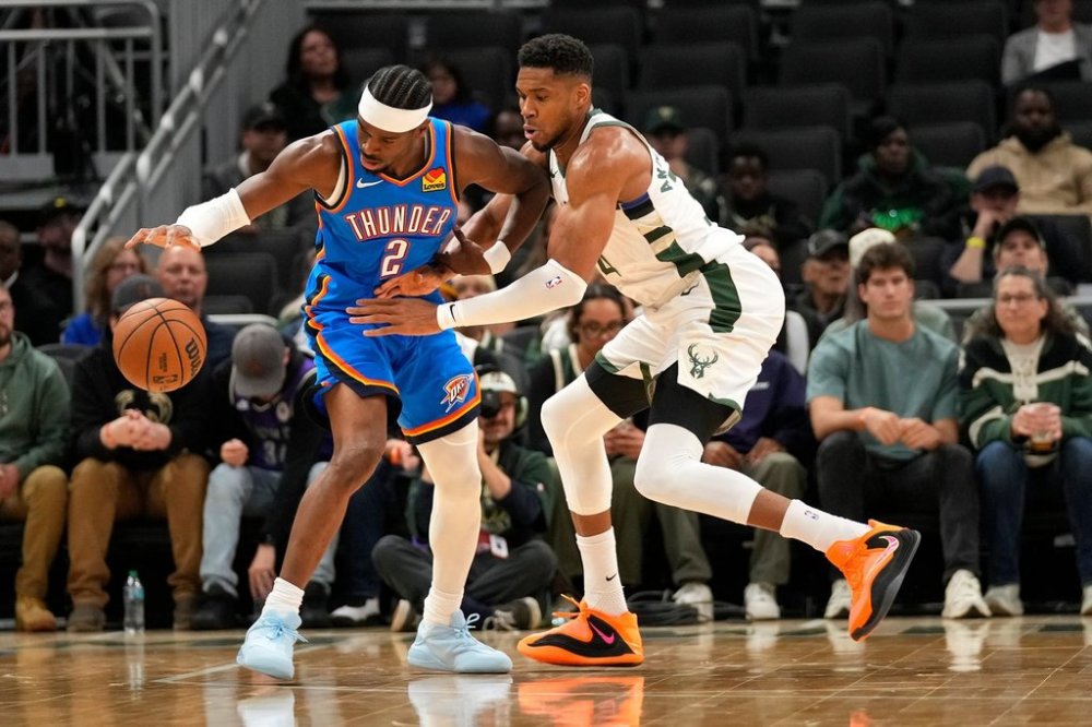 Oklahoma City Thunder guard Shai Gilgeous-Alexander (2) dribbles the ball against Milwaukee Bucks forward Giannis Antetokounmpo, right, during the first half of a preseason NBA basketball game Tuesday, Oct. 14, 2025, in Milwaukee. (AP Photo/Kayla Wolf)