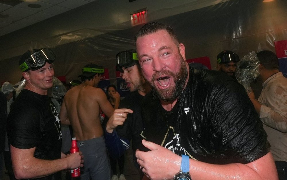 Toronto Blue Jays manager John Schneider celebrates with players and coaches in the locker-room after beating the Yankees in Game 4 of baseball's American League Division Series on Oct. 8, 2025, in New York. (AP Photo/Frank Franklin II)