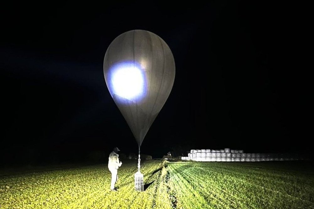 In this undated photo released by the State Border Guard Service, an officer inspects a balloon used to carry cigarettes into Lithuania, because Belarussian smugglers often use them to ferry the contraband into the European Union (State Border Guard Service via AP)