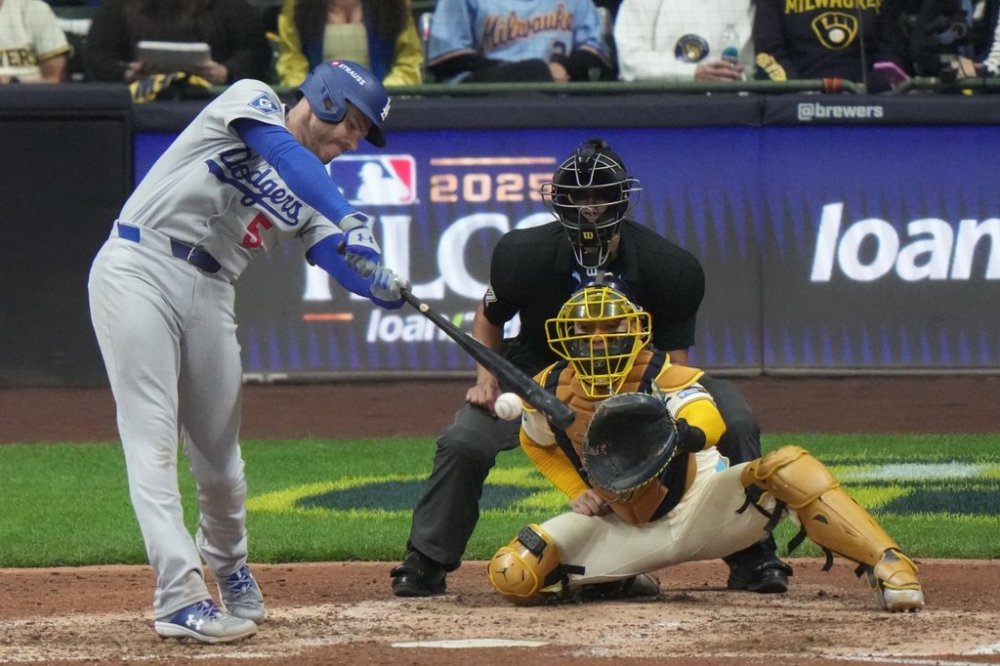 Los Angeles Dodgers' Freddie Freeman hits a single during the ninth inning of Game 2 of baseball's National League Championship Series against the Milwaukee Brewers Tuesday, Oct. 14, 2025, in Milwaukee. (AP Photo/Morry Gash)