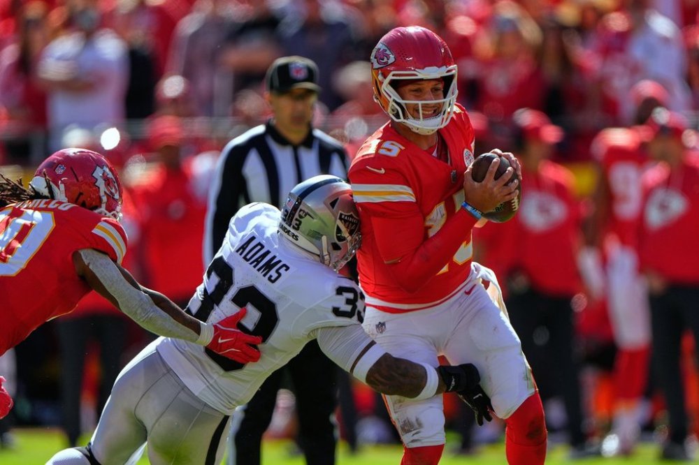 Kansas City Chiefs quarterback Patrick Mahomes, right, is sacked by Las Vegas Raiders linebacker Jamal Adams (33) during the first half of an NFL football game Sunday, Oct. 19, 2025, in Kansas City, Mo. (AP Photo/Charlie Riedel)