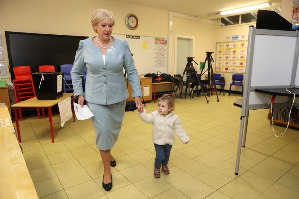 Fine Gael candidate Heather Humphreys casts her vote with the help of her one-year-old grandaughter Charlotte at Killeevan Central National School in Newbliss, Co Monaghan, for the election for the next Irish president, Friday, Oct. 24, 2025. (Liam McBurney/PA Wire/PA via AP)