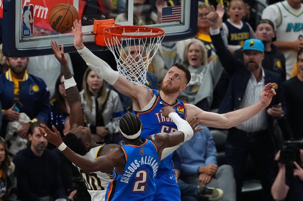 Indiana Pacers' Bennedict Mathurin (00) puts up a shot against Oklahoma City Thunder's Shai Gilgeous-Alexander (2) and Isaiah Hartenstein (55) during overtime of an NBA basketball game, Thursday, Oct. 23, 2025, in Indianapolis. (AP Photo/Darron Cummings)