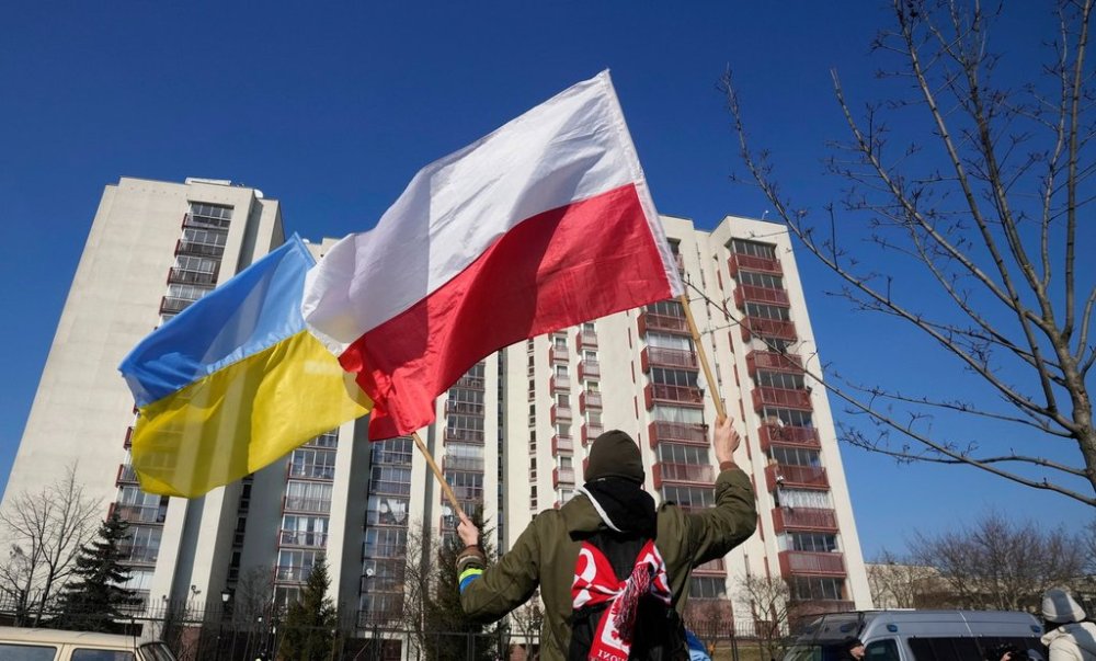 FILE - A man waves the Ukrainian and Polish flag during a demonstration in front of a building housing Russian diplomats in Warsaw, Poland, March 13, 2022. (AP Photo/Czarek Sokolowski, File)