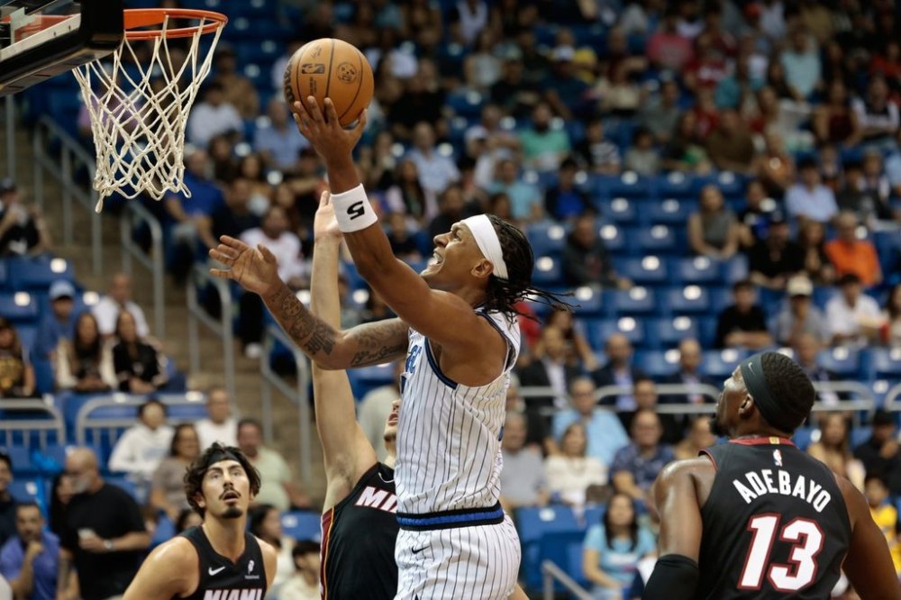 Orlando Magic forward Paolo Banchero, center, drives to the basket against the Miami Heat during the first half of a preseason NBA basketball game in San Juan, Puerto Rico, Saturday, Oct. 4, 2025. (AP Photo/Alejandro Granadillo)