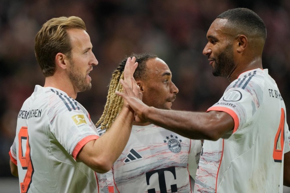 Bayern's Harry Kane, left, celebrates with team mate Jonathan Tah after scoring his side's second goal during the Bundesliga soccer match between Eintracht Frankfurt and FC Bayern Munich in Frankfurt, Germany, Saturday, Oct. 4, 2025. (AP Photo/Michael Probst)