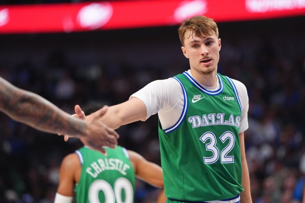 Dallas Mavericks forward Cooper Flagg (32) gets a congratulations from a teammate during the first half of an NBA basketball game against the Toronto Raptors in Dallas, Sunday, Oct. 26, 2025. (AP Photo/LM Otero)