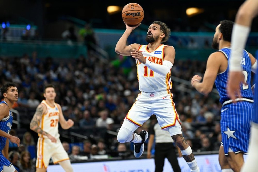 Atlanta Hawks guard Trae Young (11) goes up to shoot in front of Orlando Magic guard Tyus Jones (2) during the first half of an NBA basketball game Friday, Oct. 24, 2025, in Orlando, Fla. (AP Photo/Phelan M. Ebenhack)