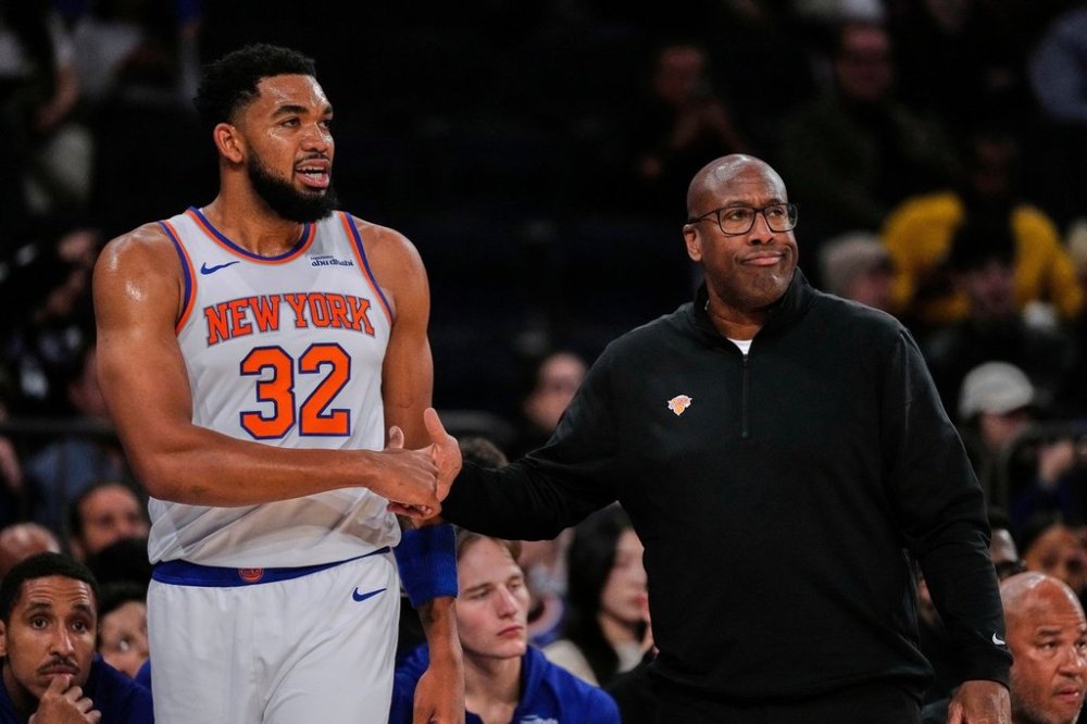 New York Knicks' Karl-Anthony Towns (32) exchanges words with Head Coach Mike Brown during the first half of a preseason NBA basketball game Thursday, Oct. 9, 2025, in New York. (AP Photo/Frank Franklin II)